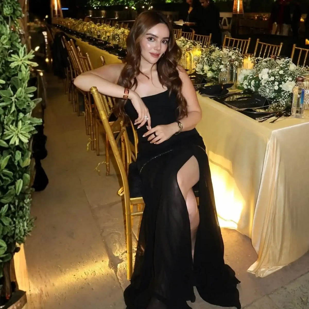 Black satin gown with a high slit and strapless design