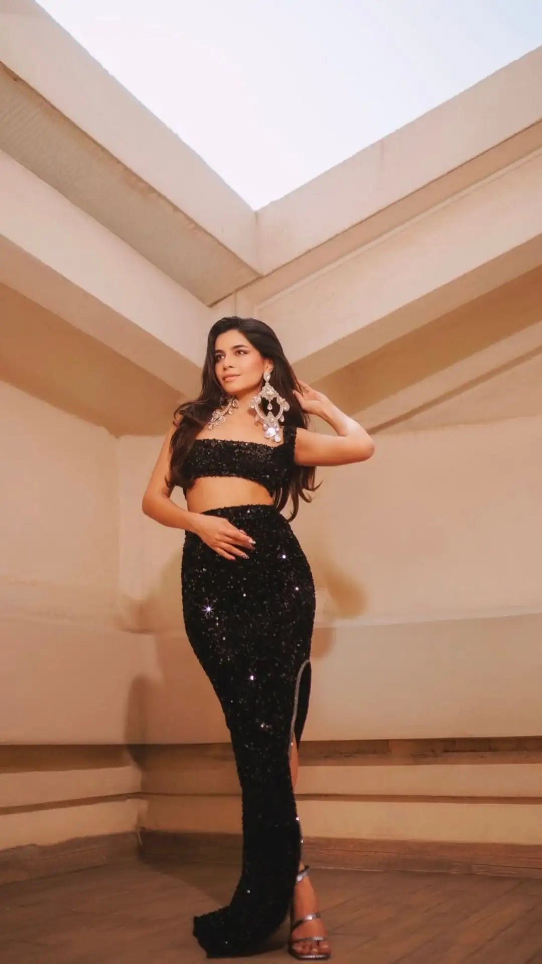 Black sequined two-piece outfit with high slit and floral embellishment on top.shop_this_look_ajtDhq