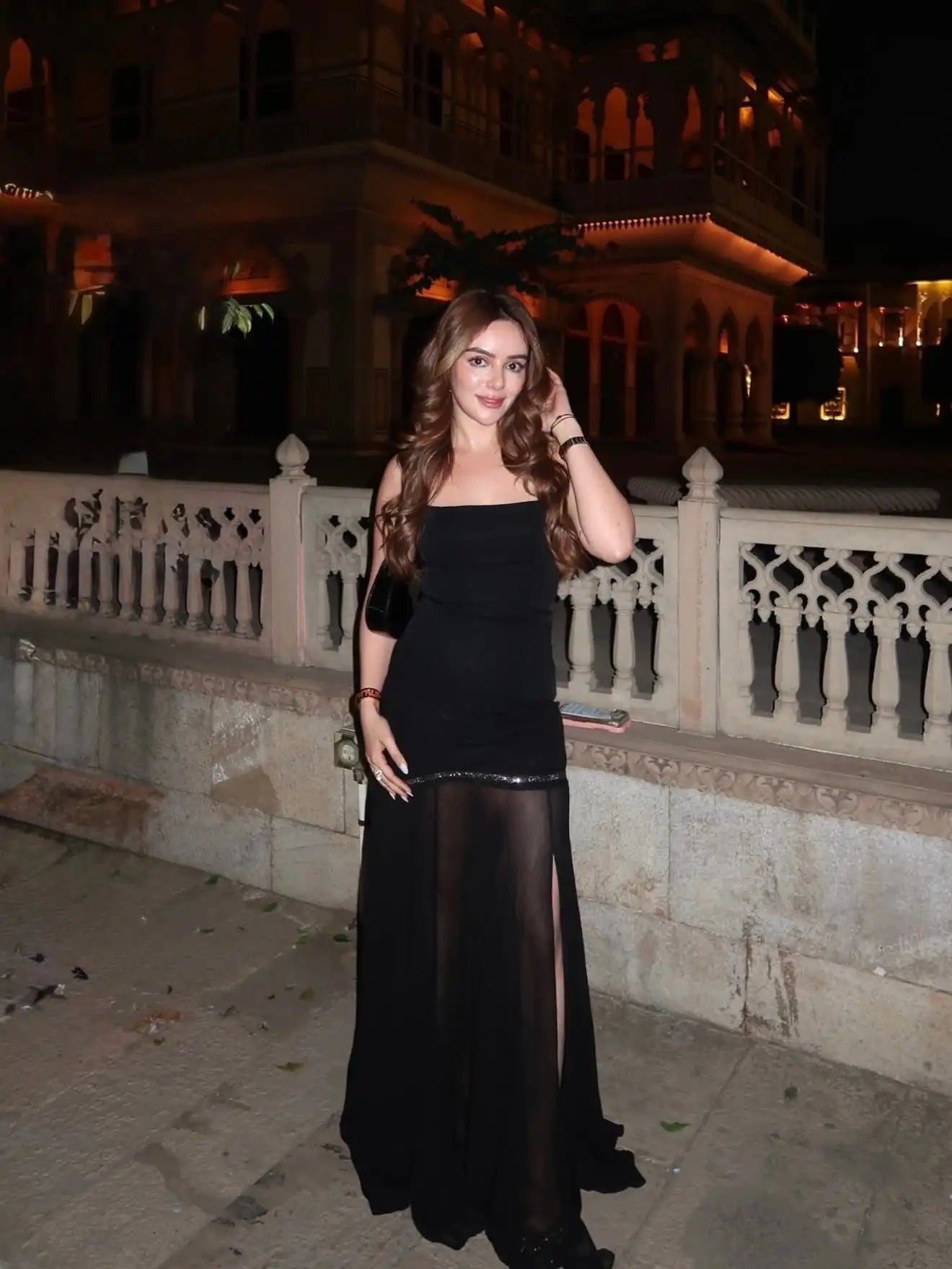 Black strapless gown with sheer overlay and high slit