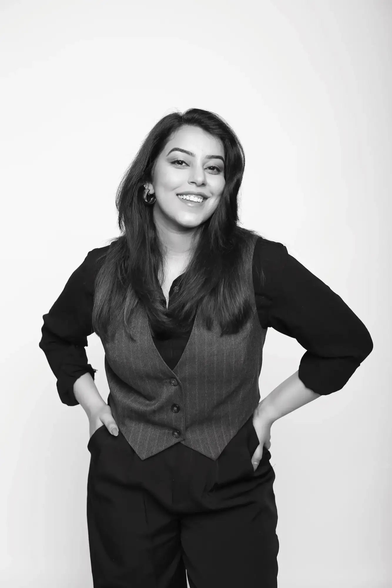 Black and white striped vest with button closure, dark pants.