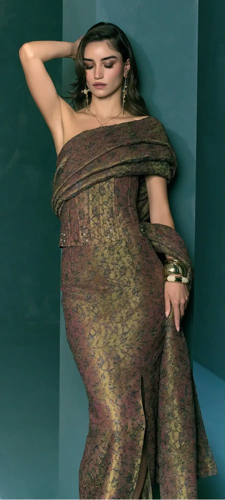 A shimmering brown and gold patterned off-shoulder gown with intricate lace detailing.