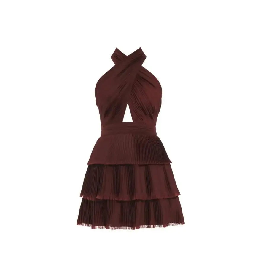 A burgundy pleated tiered mini dress with a halter neckline and a triangular cutout at the bust.