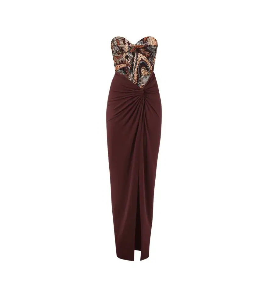 A burgundy strapless gown with a patterned bodice and a draped front.