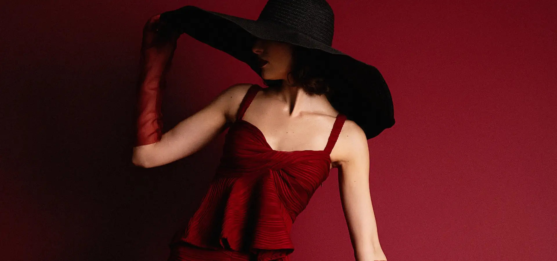 Red peplum dress with black wide-brimmed hat and long gloves.