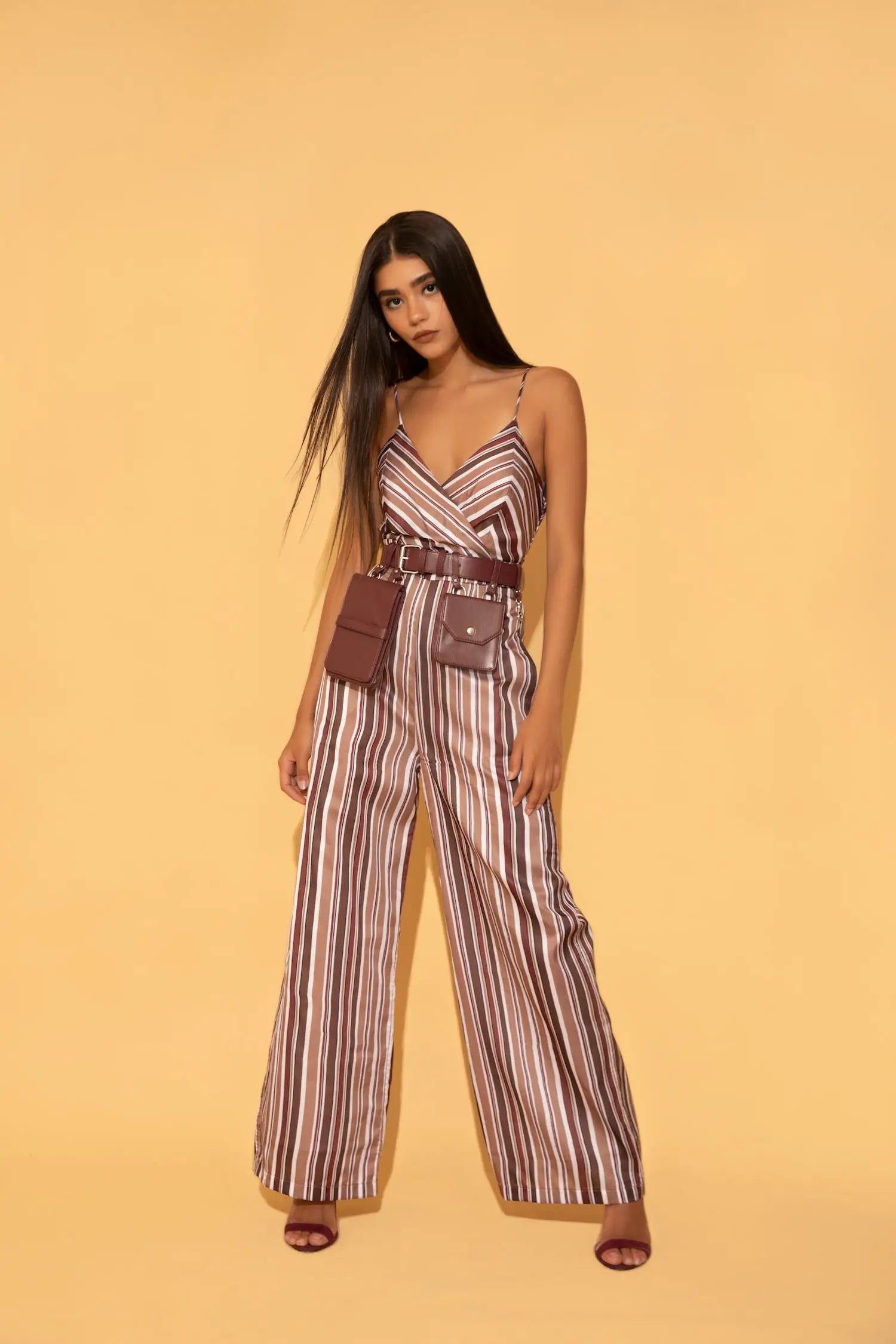 Stripe jumpsuit paired with wine coloured utility bag belt from Torqadorn