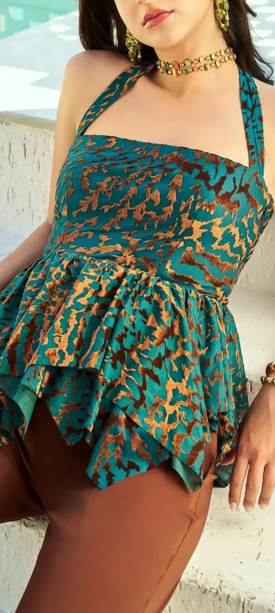Teal and gold leopard-print halter top with ruffled peplum detail.