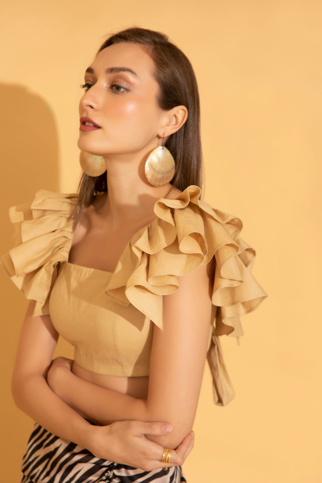 Playful and fun ruffles as seen on a beige cotton top from Torqadorn