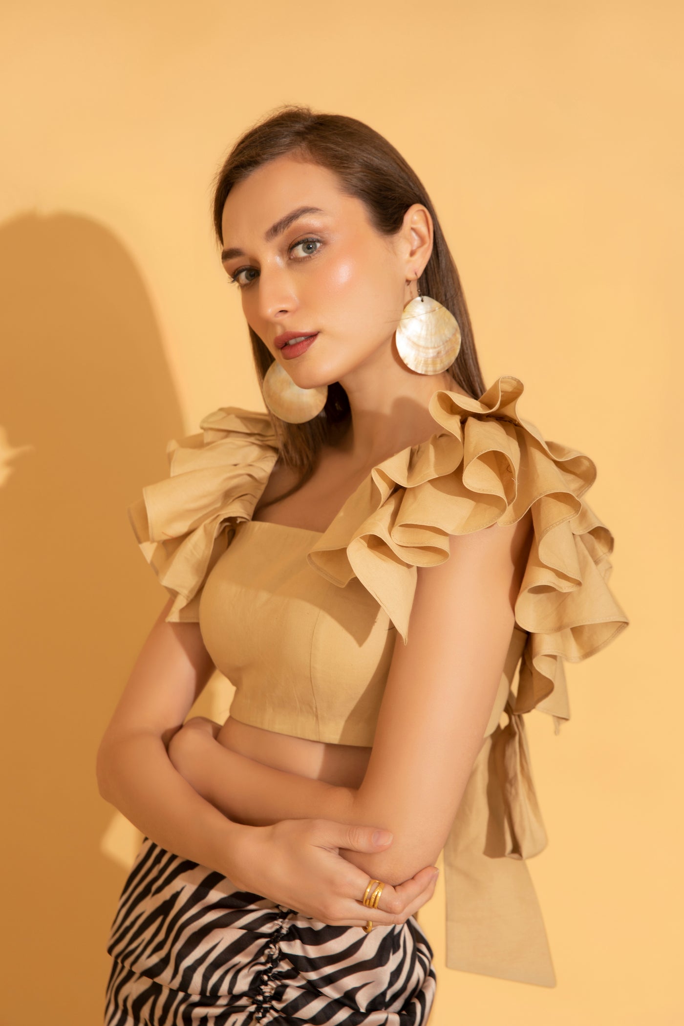 Playful and fun ruffles as seen on a beige cotton top from Torqadorn