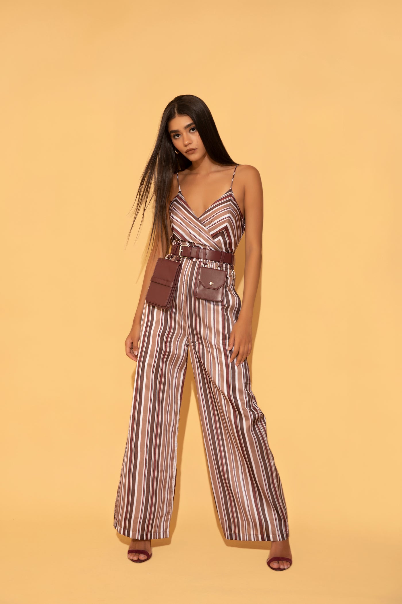 Stripe jumpsuit paired with wine coloured utility bag belt from Torqadorn